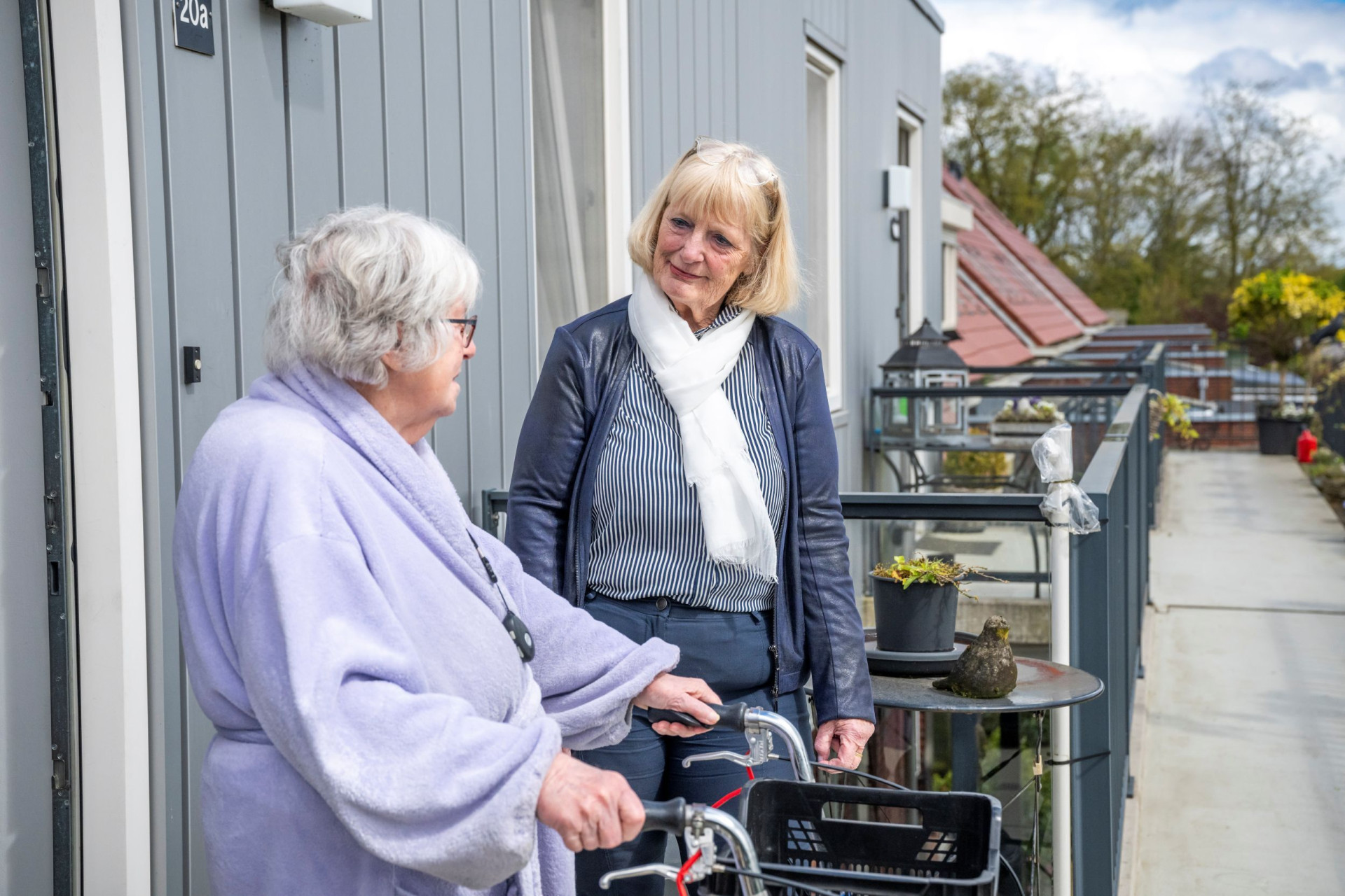Twee huurders in gesprek op een balkon
