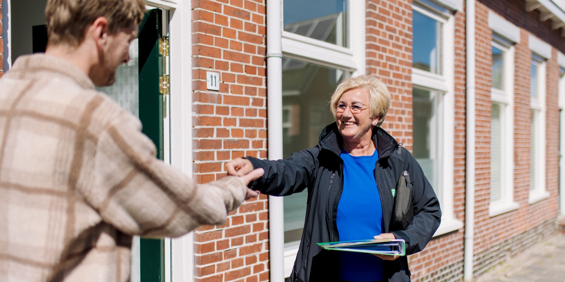 Huurder ontvangt de sleutel van nieuwe woning